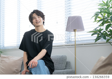 Young man relaxing by the window Young man relaxing by the window 138266359