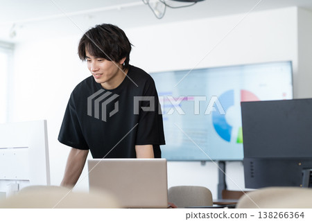 A young male engineer working on his office computer. 138266364