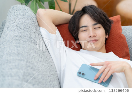 A young man taking a nap on the sofa A young man taking a nap on the sofa 138266406