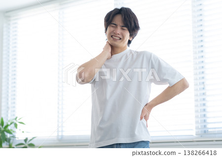 A young man stretching in his living room A young man stretching in his living room 138266418