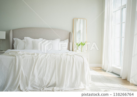 Stylish loft bedroom interior. Spacious design apartment with light walls large windows big bed. Clean modern decoration with elegant furniture in minimalist Scandinavian style 138266764