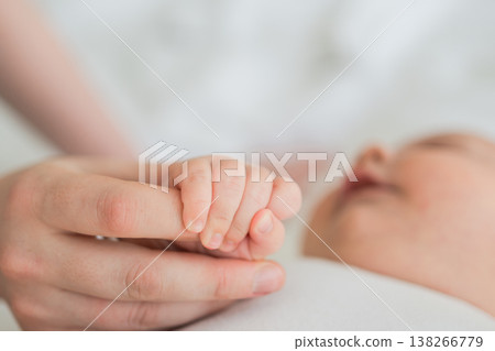 Happy family. Tiny newborn infant baby little hand on mother hand palm. Newborn baby holding parent finger after birth. Mom baby at home. Support protection of new life. Handle with care 138266779