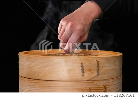 During the Dragon Boat Festival, a close-up shot captures the moment the bamboo steamer lid is opened, revealing the rice dumplings. During the Dragon Boat Festival, a close-up shot captures the moment the bamboo steamer lid is opened, revealing the rice dumplings. 138267161