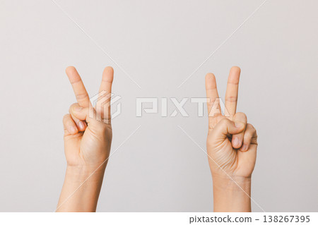 Two hands showing peace and victory V sign gesture isolated on light gray background with copy space, minimalist studio concept for freedom, unity, nonviolence and positive campaigns. peace, victory Two hands showing peace and victory V sign gesture isolated on light gray background with copy space, minimalist studio concept for freedom, unity, nonviolence and positive campaigns. peace, victory 138267395