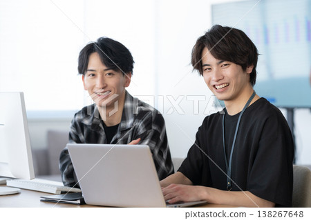 一位年輕的男工程師正在辦公室電腦前工作。 138267648