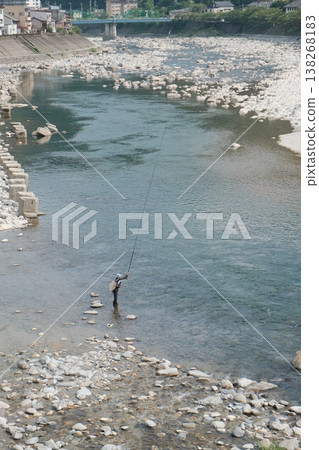Angler Casting Line Beside Rocky Riverbank Angler Casting Line Beside Rocky Riverbank 138268183