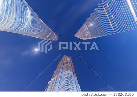 A composition that looks up at the cluster of Shanghai's skyscrapers towering against the blue sky of a moonlit night. A composition that looks up at the cluster of Shanghai's skyscrapers towering against the blue sky of a moonlit night. 138268190