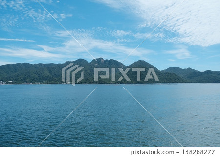 Green Mountains Reflecting On Calm Blue Water 138268277