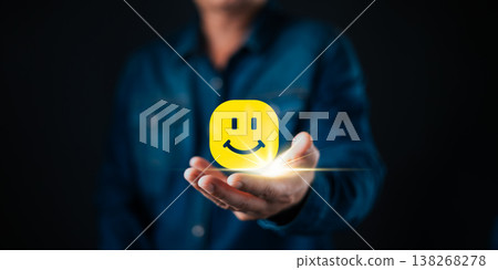 A person holding a glowing smile face icon symbolizes customer satisfaction, positive feedback, happiness, and quality service in business success and relationship management. A person holding a glowing smile face icon symbolizes customer satisfaction, positive feedback, happiness, and quality service in business success and relationship management. 138268278