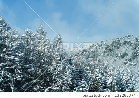 A winter landscape of snow-covered mountains seen from the bus window. A winter landscape of snow-covered mountains seen from the bus window. 138269374