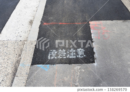 Temporary paving and signs warning of uneven surfaces on the sidewalk after waterworks construction. Temporary paving and signs warning of uneven surfaces on the sidewalk after waterworks construction. 138269570