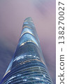 仰望一座螺旋狀的玻璃摩天大樓，它蜿蜒向上，直入粉紅色的雲層天空。 138270027