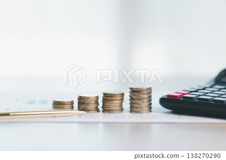 Stacks of coins on financial report with charts, blurred calculator in background, symbolizing savings, investment growth, budgeting and wealth management for business planning strategy. saving Stacks of coins on financial report with charts, blurred calculator in background, symbolizing savings, investment growth, budgeting and wealth management for business planning strategy. saving 138270290