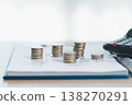 Stacks of coins on financial report with charts, blurred calculator in background, symbolizing savings, investment growth, budgeting and wealth management for business planning strategy. saving 138270291