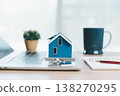 Home buying and mortgage planning concept for real estate investment and insurance, featuring a miniature house, keys, calculator, pen and contract on a bright desk in a modern office. real estate 138270295