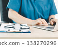Medical professional in blue scrubs using tablet and stylus with stethoscope, documenting patient records at clinic desk, concept of digital health, telemedicine and modern healthcare workflow. 138270296
