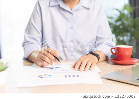 Business professional working on laptop at modern office desk with documents, smartphone and stationery, bright daylight by window. Concept of productivity, remote work and digital management. Business professional working on laptop at modern office desk with documents, smartphone and stationery, bright daylight by window. Concept of productivity, remote work and digital management. 138270302