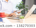 Business professional working on laptop at modern office desk with documents, smartphone and stationery, bright daylight by window. Concept of productivity, remote work and digital management. 138270303