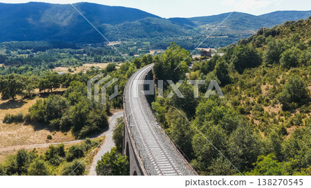 Curved railway viaduct extending through green landscape Curved railway viaduct extending through green landscape 138270545