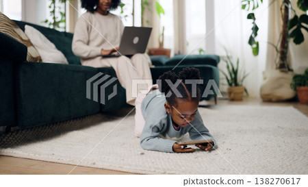Mother working from home while daughter playing with phone Mother working from home while daughter playing with phone 138270617