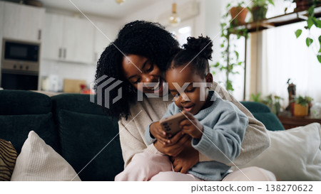 African American mother and daughter laughing using smartphone 138270622