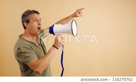Man holding megaphone shouting pointing communicating direction Man holding megaphone shouting pointing communicating direction 138270702