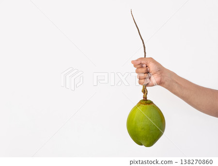 Holding fresh organic coconut in hand, isolated on white background. Holding fresh organic coconut in hand, isolated on white background. 138270860