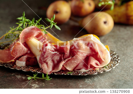 Prosciutto with pears and thyme on a silver tray. 138270908