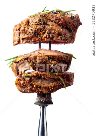 Beef steak on a fork isolated on a white background. Beef steak on a fork isolated on a white background. 138270932