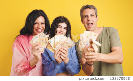Happy family holding euro banknotes celebrating financial success Happy family holding euro banknotes celebrating financial success 138270968