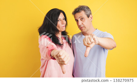 Mature couple showing thumbs down gesture disapproval 138270975