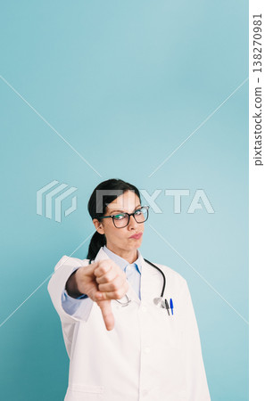 Female doctor showing disapproval with thumbs down gesture 138270981