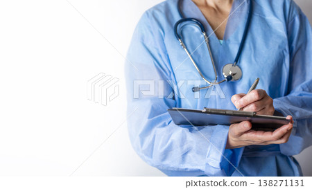 Female caucasian doctor filing papers in clipboard. Healthcare background with copy-space Female caucasian doctor filing papers in clipboard. Healthcare background with copy-space 138271131