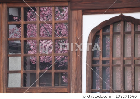 The scenery of pink cherry blossoms reflected in the temple window. The scenery of pink cherry blossoms reflected in the temple window. 138271560