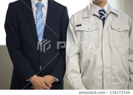 Two young businessmen, one in a suit and the other in work clothes, stand side by side. Two young businessmen, one in a suit and the other in work clothes, stand side by side. 138272544
