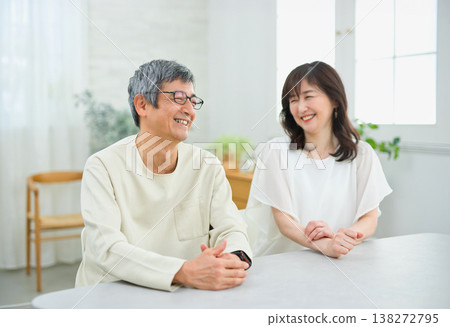 A couple in their 60s having a fun conversation in the living room A couple in their 60s having a fun conversation in the living room 138272795