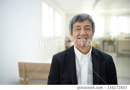 一位六十多歲的男子穿著夾克,在房間裡微笑。 一位六十多歲的男子穿著夾克,在房間裡微笑。 138272883
