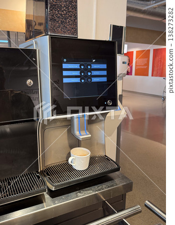 Coffee machine dispensing drink into white cup on metal grid surface. Morning routine, self service, quick break, urban convenience, everyday habit, modern appliance usage Coffee machine dispensing drink into white cup on metal grid surface. Morning routine, self service, quick break, urban convenience, everyday habit, modern appliance usage 138273282
