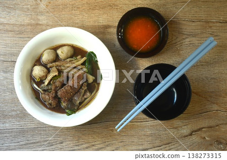 boiled braised beef meat and meatball couple organ in herb black soup on bowl dipping spicy chili sauce  138273315