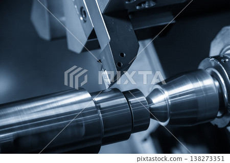 High-precision CNC lathe machine performing a finish cut on a metal shaft part for a smooth surface finish. High-precision CNC lathe machine performing a finish cut on a metal shaft part for a smooth surface finish. 138273351