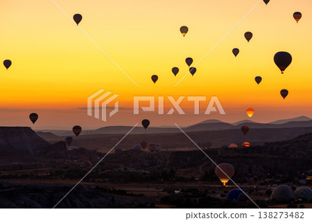 Hot air balloon flying over rocky landscape at sunrise in Cappadocia. Turkey Hot air balloon flying over rocky landscape at sunrise in Cappadocia. Turkey 138273482