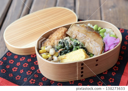 Japanese-style bento box with teriyaki yellowtail and edamame and salted kelp rice. 138273633
