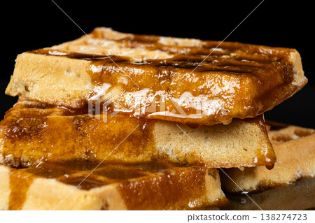 Delicious Belgian waffles topped with sweet caramel syrup close up. Delicious Belgian waffles topped with sweet caramel syrup close up. 138274723