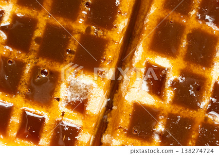 Delicious Belgian waffles topped with sweet caramel syrup close up. Delicious Belgian waffles topped with sweet caramel syrup close up. 138274724