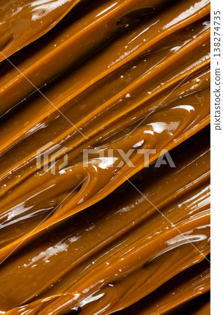 Thick caramel sauce swirl with glossy finish macro. Thick caramel sauce swirl with glossy finish macro. 138274735