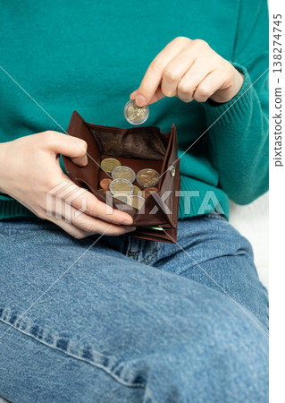 Hands and a wallet with mixed euro coins. Concept of financial struggle and savings Hands and a wallet with mixed euro coins. Concept of financial struggle and savings 138274745