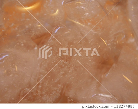 Macro photography of ice in a glass and an amber-colored beverage. Macro photography of ice in a glass and an amber-colored beverage. 138274995