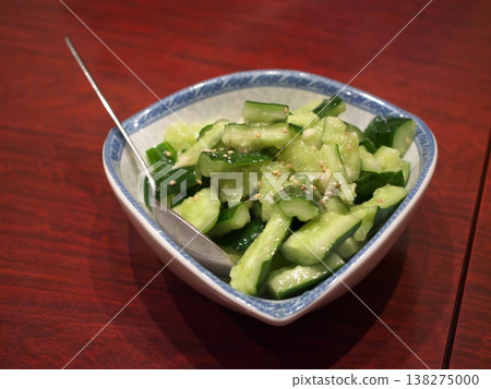 A Chinese-style cucumber and garlic salad served on a white plate. 138275000