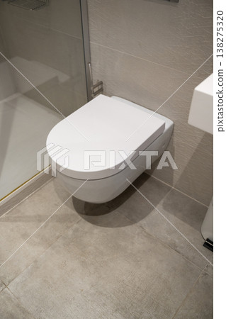 Modern bathroom interior featuring a contemporary wall-hung toilet, highlighting minimalist design, hygienic surfaces, and efficient space utilization in a clean urban apartment setting Modern bathroom interior featuring a contemporary wall-hung toilet, highlighting minimalist design, hygienic surfaces, and efficient space utilization in a clean urban apartment setting 138275320