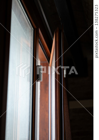 Wireless contact sensor protecting an open wooden window frame, ensuring smart home security and property protection for modern residential living spaces Wireless contact sensor protecting an open wooden window frame, ensuring smart home security and property protection for modern residential living spaces 138275323